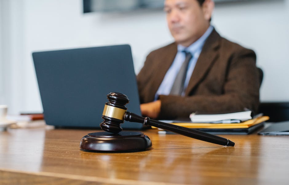 Image description: A person holding a gavel in a courtroom, symbolizing the legal process for assault and battery charges