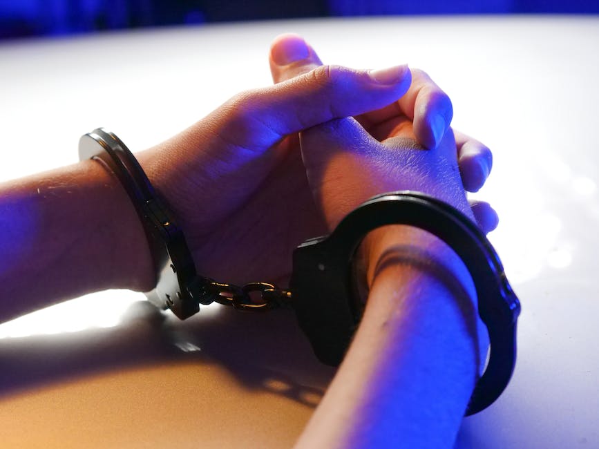 Image illustrating the concept of wrongful arrest, depicting a person being handcuffed with a crossed-out symbol on their body.