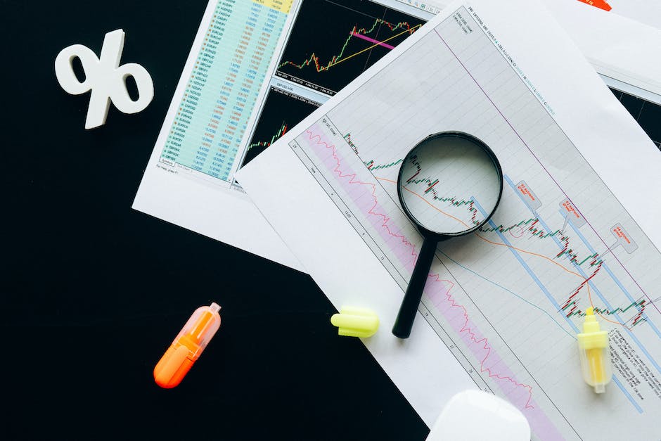 Image depicting a magnifying glass examining financial documents