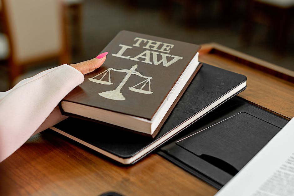 Image of a courtroom showing a defense attorney and a prosecutor discussing a plea bargain with a judge presiding.