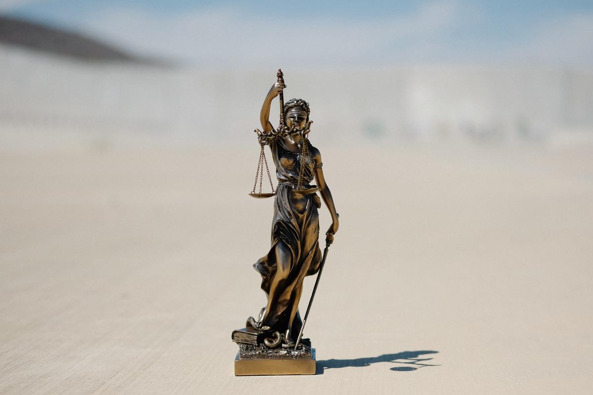 Illustration of an attorney symbolically holding the scales of justice in hand, depicting the rewards and challenges of pro bono legal services.